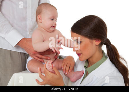 Ein Foto von weiblichen Kinderarzt untersuchen Fuße des jungen durch Vater Seitenansicht des Arztes Überprüfung Kleinkind statt Stockfoto