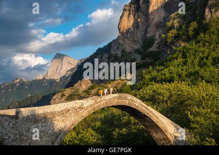 Die alte Steinbrücke über den Fluss Aoos bei Konitsa mit Mount Tymfi in den Hintergrund, Epirus, Nordgriechenland. Stockfoto