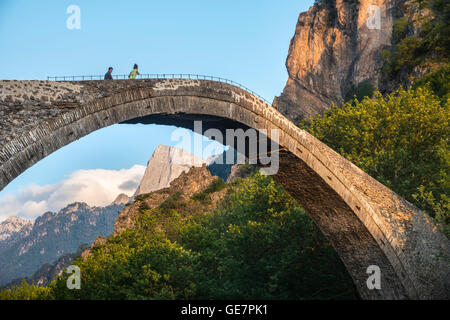 Die alte Steinbrücke über den Fluss Aoos bei Konitsa mit Mount Tymfi in den Hintergrund, Epirus, Nordgriechenland. Stockfoto