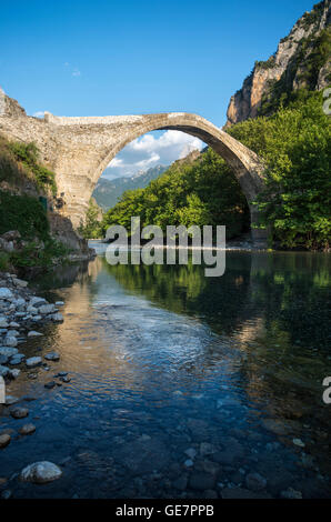 Die alte Steinbrücke über den Fluss Aoos bei Konitsa mit Mount Tymfi in den Hintergrund, Epirus, Nordgriechenland. Stockfoto