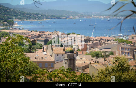 St Tropez, wo die roten Dächer der Häuser und der azurblaue Küste entfernt am Horizont die Berge. Stockfoto