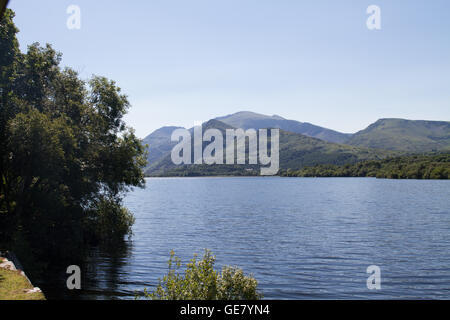 Der Blick der Snowdon von geschleppt Dampfzug auf Llanberis Lake Railway auf einem strahlend blauen Himmel Sommertag Stockfoto