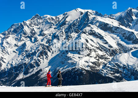 Skifahrer im Skigebiet Les Contamines-Montjoie gegen das Mont Blanc Massiv, Haute-Savoie, Frankreich Stockfoto