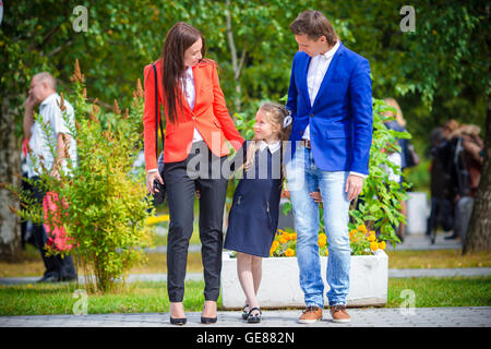 Eltern Theiir bringt kleine süße Tochter zur Schule. Entzückende kleine Mädchen Gefühl begeistert wieder zur Schule gehen Stockfoto