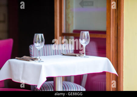 Weißen Holztische mit Stühlen am Sommer geöffnet Caféterrasse im Freien. Blick auf leere Straßencafé in Europa. Stockfoto