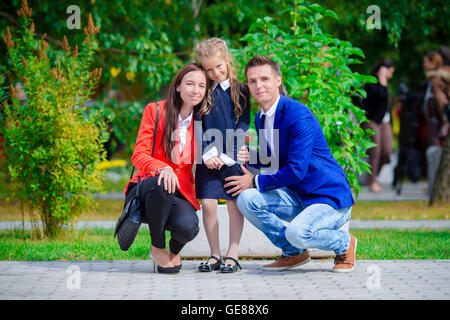 Eltern Theiir bringt kleine süße Tochter zur Schule. Entzückende kleine Mädchen Gefühl begeistert wieder zur Schule gehen Stockfoto