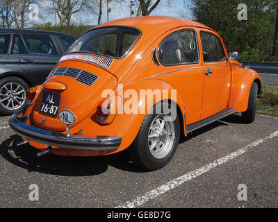 Dieses Bild zeigt einen 1972er Volkswagen Beetle (Kever) in leuchtendem Orange, der sein kultiges Design zeigt. Das Auto repräsentiert die Automobilkultur der 1970er Jahre und ist ein Symbol für Oldtimer-Liebhaber. Stockfoto