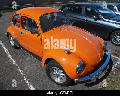 Dieses Foto zeigt einen 1972er Volkswagen Kever (Kever) in Orange. Der Oldtimer ist in seiner ursprünglichen Form gehalten und zeigt die kultige runde Form und die lebendige Farbe, die den VW Käfer zu einem zeitlosen Symbol der Automobilkultur gemacht haben. Stockfoto