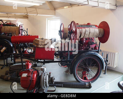Dieses Bild zeigt einen antiken Feuerwehrwagen aus den Niederlanden, bekannt als *Oude brandweeraanhanger*. Der Vintage-Feuerwehrwagen hebt die Technik und die Transportausrüstung der frühen Brandbekämpfung hervor. Stockfoto