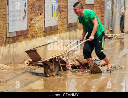 Xingtai, Chinas Provinz Hebei. 25. Juli 2016. Ein Mann schiebt einen Wagen, versandet in Daxian Dorf Xingtai, Provinz Hebei North China, 25. Juli 2016 zu löschen. Insgesamt 1,678 Millionen Menschen sind betroffen, durch sintflutartige Regenfälle vom 19. Juli bis 21. Bildnachweis: Zhu Xudong/Xinhua/Alamy Live-Nachrichten Stockfoto