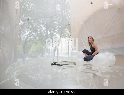 Bochum, Deutschland. 23. Juli 2016. Studentin Franziska sitzt in einer Haus-Blase zwischen Gebäuden in Bochum, Deutschland, 23. Juli 2016. Architektur-Studenten in Bochum begann am Freitag ein Experiment über die Zukunft der studentisches Wohnen. Sie installiert eine Art Blase transluzente Kunststoff in den schmalen Spalt zwischen zwei Wohnhäusern, einem Raum von etwa drei Metern, die eingegeben werden können, mit Hilfe einer Leiter über eine Telefonzelle, die zu einer Dusche umfunktioniert wurde. Foto: MARCEL KUSCH/Dpa/Alamy Live News Stockfoto