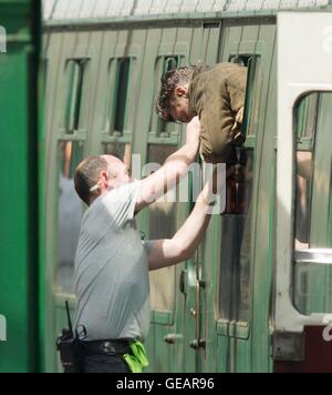 Swanage, Dorset, UK-Station.  25. Juli 2016. Verfilmung von Dünkirchen (Bogeda Bay) in Swanage Station in Dorset.  Harry Styles wird in dem Zugfenster stecken und muss geholfen werden durch ein Mitglied der Besatzung zu befreien, während der Dreharbeiten zu einer Szene in Swanage Station, die als Woking verdoppelt, wo He Swiggs Bier und isst Äpfel während hängen aus dem Zugfenster bei der Ankunft auf der Plattform.  Foto von Graham Hunt/Alamy Live-Nachrichten Stockfoto