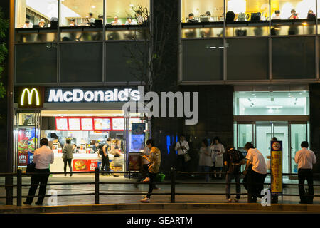 Menschen spielen Pokemon gehen vor McDonald's-Restaurant in Akihabara am 25. Juli 2016, Tokio, Japan. Nach dem Start des Pokemon gehen erinnert Sehenswürdigkeiten und Sommer-Festival-Organisatoren app-Nutzer zu respektieren Manieren und seien Sie sich bewusst von Menschen um sie herum. In der Zwischenzeit installiert JR East-Bahn-Linie Plakate in Shinjuku Station, einer der verkehrsreichsten Bahnhöfe der Welt, zur Achtung Pendler über die Gefahren der Verwendung von mobiler Geräts, um Spiele zu spielen, während in der Station zu Fuß. © Rodrigo Reyes Marin/AFLO/Alamy Live-Nachrichten Stockfoto