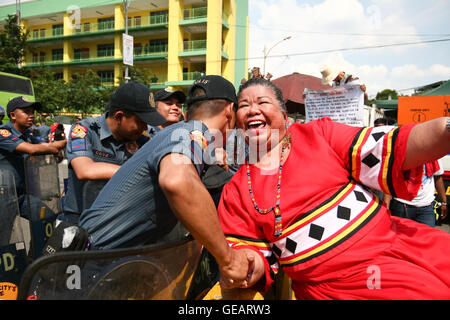 Quezon City, Philippinen. 25. Juli 2016. Commediene und Aktivist MAE Panel rechts, bekannt als "Juana Change," teilt ein paar Lacher mit Polizei bewacht die Barrikade in der Nähe der Batasang Pambansa, wo Tausende AktivistInnen marschierten zum House Of Representatives Präsident Duterte auf seine erste Rede zur Lage der Nation ihre Unterstützung gewähren. © J Gerard Seguia/ZUMA Draht/Alamy Live-Nachrichten Stockfoto