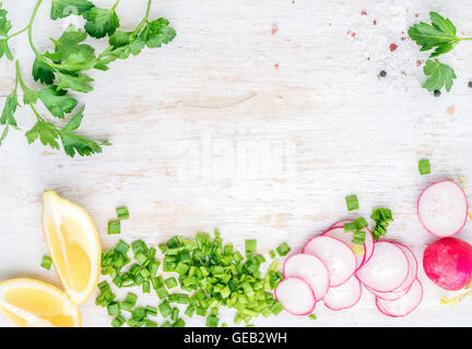 Weiße Holzküche Tabellenhintergrund mit gesunde Kochzutaten und Textfreiraum. Gemüse, Kräuter für Salat Stockfoto