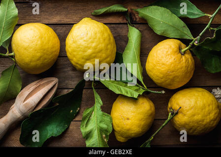 Frische Zitronen mit Blättern in rustikalen Holzkiste Stockfoto