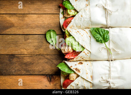 Gesunden Mittagssnack. Tortilla wraps mit gegrilltem Hühnerfilet und frischem Gemüse Stockfoto