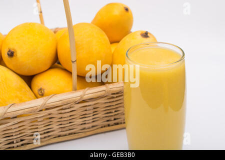 Mango-Saft mit frischem Obst auf weißem Hintergrund. Stockfoto