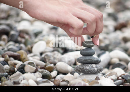 Ausgleich von Steinen mit Frau hand Stockfoto