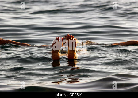 Budva, Montenegro - Frau schwimmt auf der Oberfläche des Meeres im Sommer am späten Nachmittag genießen, Sonnenbaden und Baden im Meer Stockfoto