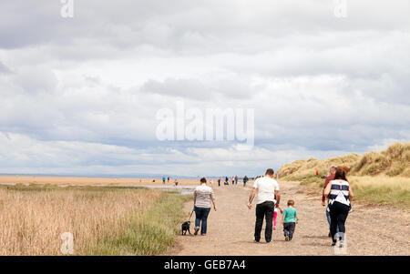 Familie der Urlauber zu Fuß entlang Presthaven Beach Resort in Gronant, Prestatyn, Wales. Stockfoto