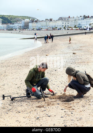 Yong-Mann und Frau Metalldetektor am Strand von Llandudno Wales GB Stockfoto