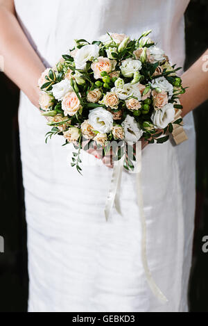 Bunten wunderschönen Brautstrauß der verschiedenen Farben der Rosen und andere Blumen in Händen der Braut im weißen Kleid. Stockfoto