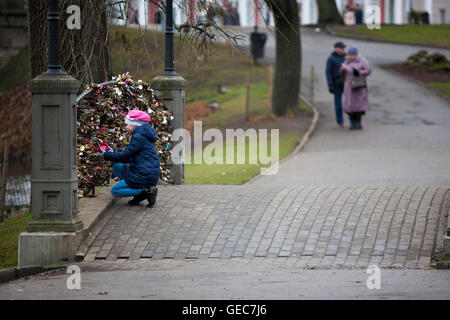 Ein Kind spielt mit der auf kleine Brücke verziert mit Schlössern im Kronvadda Park neben der Altstadt von Riga, Riga, Lettland, baltischen Staaten. Stockfoto