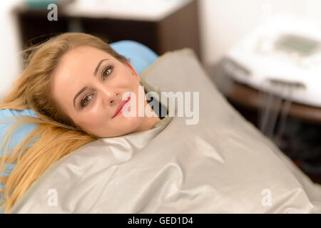 Schöne junge Frau, thermodecke Behandlung im Beauty Salon Stockfoto