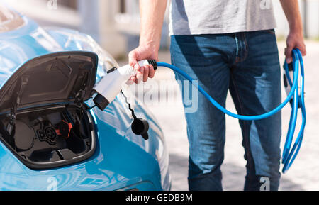 Mann des Autos Aufladen Einschalten Stockfoto