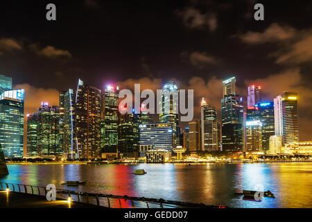 Singapur, Singapur - 29. Februar 2016: Singapur Skyline Downtown Core an der Marina Bay in der Nacht. Stadtbild von berühmten Wolkenkratzer mit Licht beleuchtet und im Wasser gespiegelt. Stockfoto