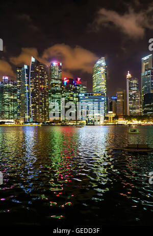 Singapur, Singapur - 2. März 2016: Singapur Skyline Downtown Core auf Marina Bay in der Dämmerung. Stadtbild von berühmten Wolkenkratzer mit Licht beleuchtet und im Wasser gespiegelt. Stockfoto