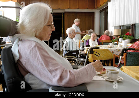 Bewohner sitzen im Speisesaal Kaffeetrinken in einem Pflegeheim Stockfoto