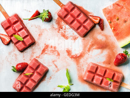 Erdbeer-Wassermelone Eis Eis am Stiel mit frischer Minze Blätter über Stahl Fach Hintergrund, Textfreiraum Stockfoto