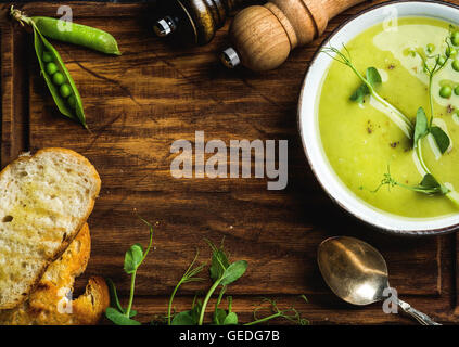 Grüne Creme Erbsensuppe auf hölzernen Hintergrund, Textfreiraum Stockfoto