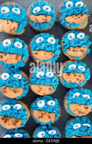 Sammlung von Cupcakes dekoriert, um einen blauen Cookie fressenden Monster aussehen Stockfoto