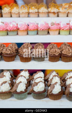 Reihen der bunten Cupcakes einschließlich Schokolade, Himbeeren, Minze Schokolade, Erdbeere, Popcorn und toffee Stockfoto