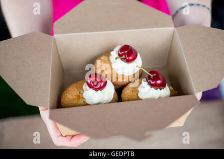 Drei Mandel Cupcakes oder Brötchen mit Mandelscheiben obendrauf, fertig mit Buttercreme Rohrleitungen und eine ganze Sahnehäubchen. Wom im Besitz Stockfoto