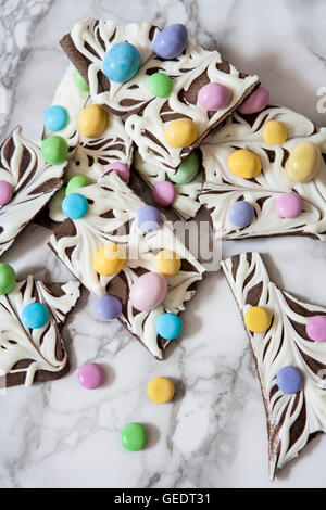 Marmorierte Schokolade Rinde mit Pastell Bonbons, Nahaufnahme Stockfoto