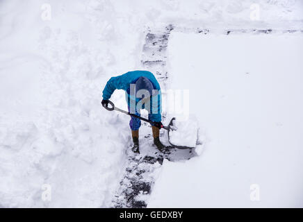 Erwachsenen Schneeschaufeln nach Wintersturm. Stockfoto