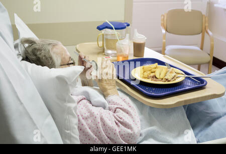 Neunzig Jahre alte Patientin Essen in NHS-Krankenhaus Krankenhaus Essen auf Tablett. UK Stockfoto