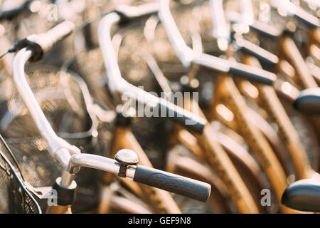 Zeile der Stadt Fahrräder Fahrräder zur Miete direkt am Bürgersteig geparkt. Fahrrad-Fahrrad-Parken In europäischen Stadt. Nahaufnahme von Lenker Stockfoto