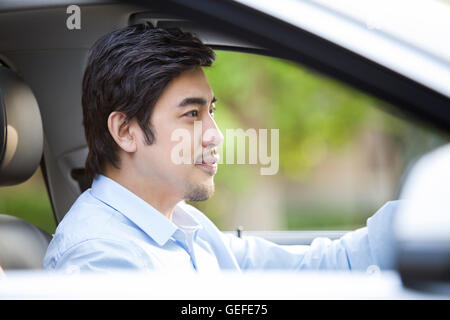 Junge Chinesen Mann Steuerwagen Stockfoto