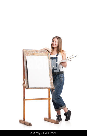 Junge lächelnde Frau an Staffelei Stockfoto