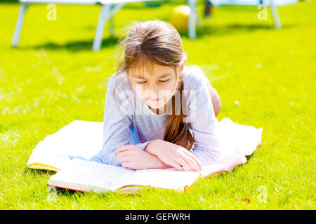 Kinder Mädchen Buch auf dem grünen Rasen Stockfoto