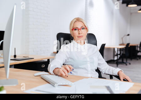 Porträt von lächelnden attraktive Reife Geschäftsfrau mit Laptop im Büro Stockfoto