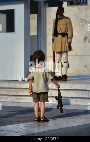 Evzone bewachen das Grab des unbekannten Soldaten in Athen von einem kleinen Jungen kopiert wird. Griechenland. Europa Stockfoto