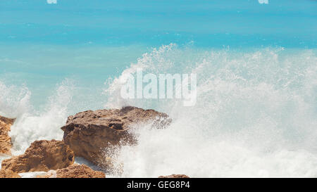 Felsiger Strand auf Lefkada Küste. Detail der brechenden Wellen am Strand, Wellen, Lefkada, Griechenland zwischen Felsen Stockfoto