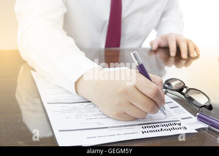 Geschäftsmann hat mit Stift Bewerbung Formular ausfüllen. Job Vacancy Konzept oder Beschäftigung Geschäftskonzept. Stockfoto