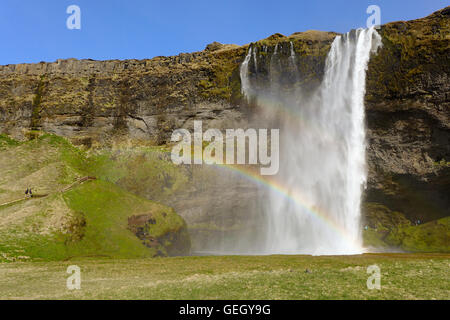 Hinter Seljalandsfoss Wasserfall in Island mit einzelnen Regenbogen; Seljalandsfoss Wasserfall Seljalandsfoss, Southern Island Stockfoto